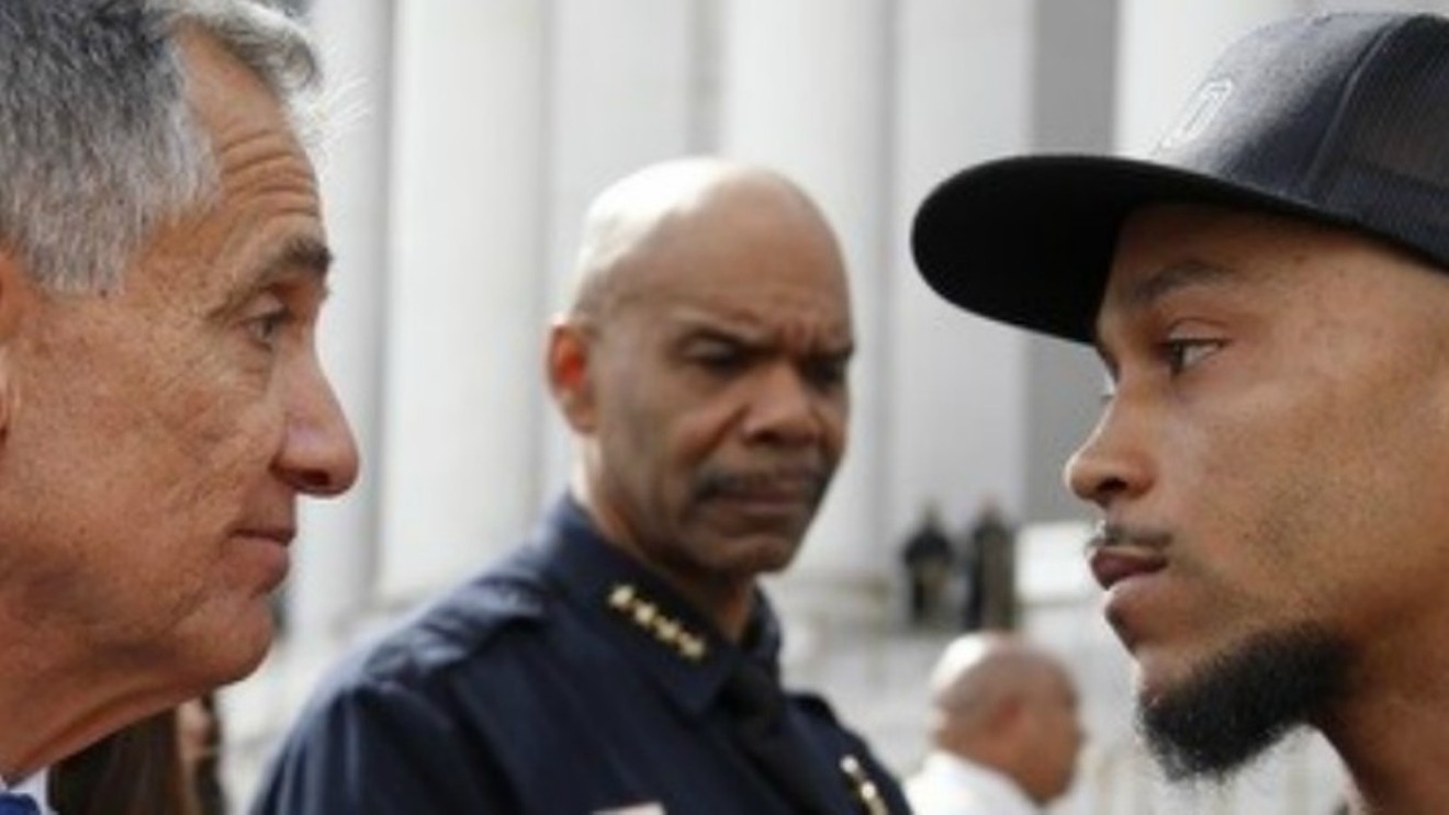 At a 2013 demonstration, Alex Landau, right, faced off against then-Manager of Safety Alex Martinez as Denver Police Chief Robert White looked on.