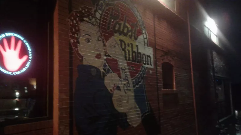 Image: Of course Rosie the Riveter drinks PBR. A mural on the side of the Highland Tavern's brick building.