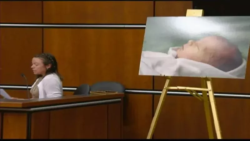 Image: woman testifying in front of baby picture