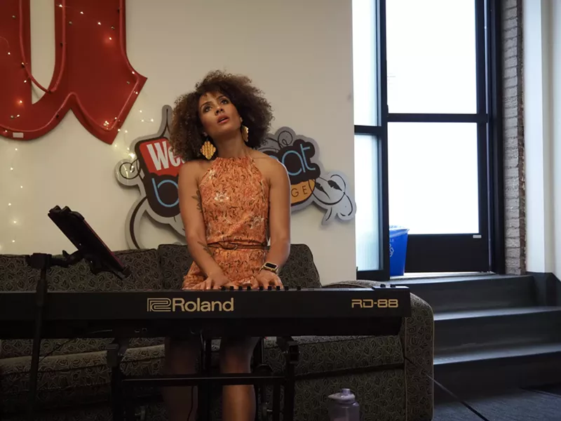 Image: woman playing a piano and looking up