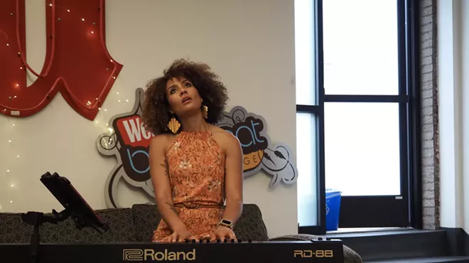 woman playing a piano and looking up