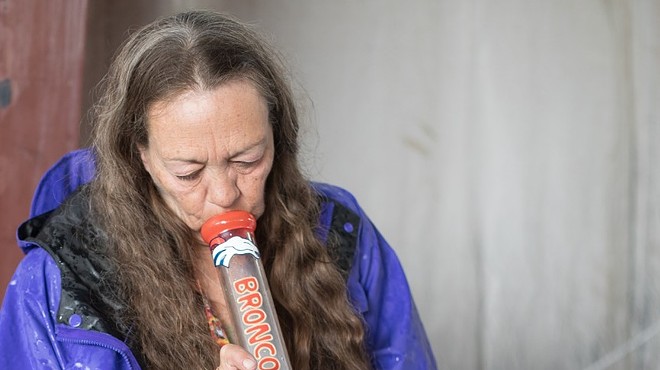 Woman smokes weed from a bong water pipe