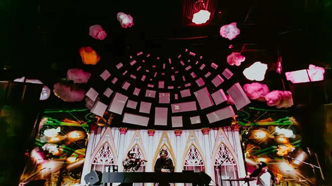 dj and violinist on stage with cathedral-inspired light show effects