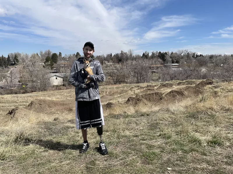 Image: Man in hoodie stands outside on grass