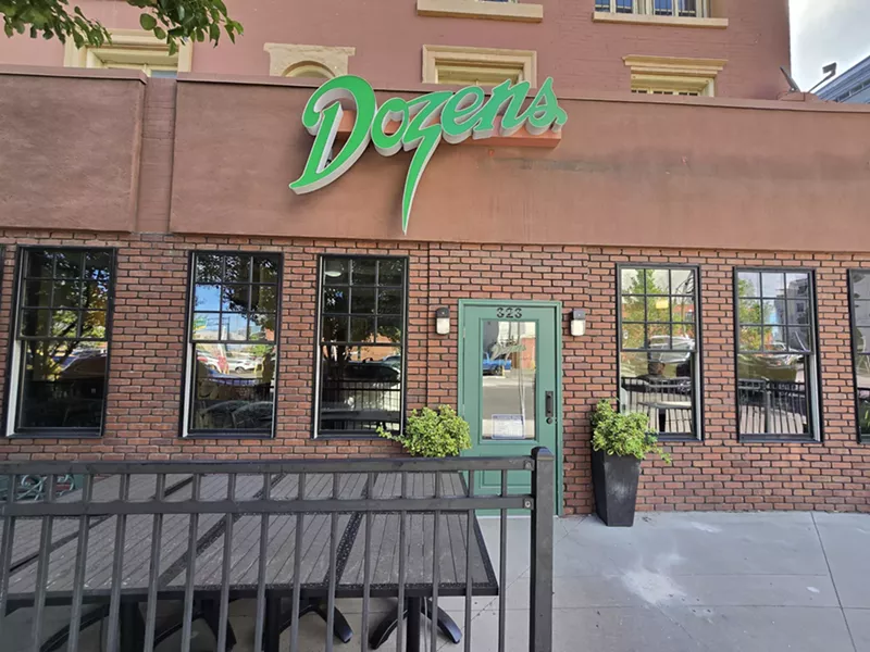 Image: green sign that says "dozens" on a brick building