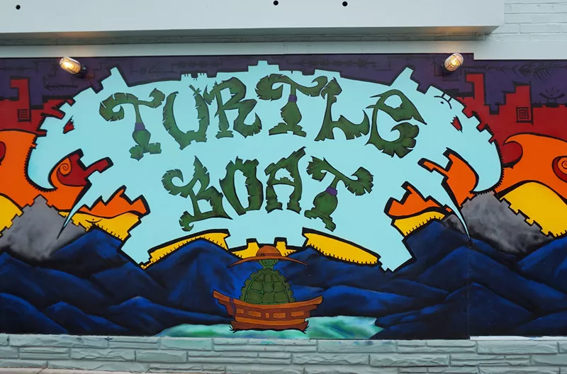 Image: a colorful mural that says "turtle boat"