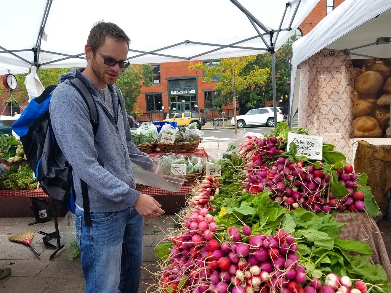 Chef Bradley Yard of Avelina shops for radishes at the Cure Organic Farm stand at the Union Station Farmers' Market.