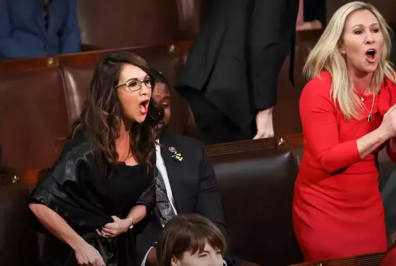Image: woman in red and women in black yelling