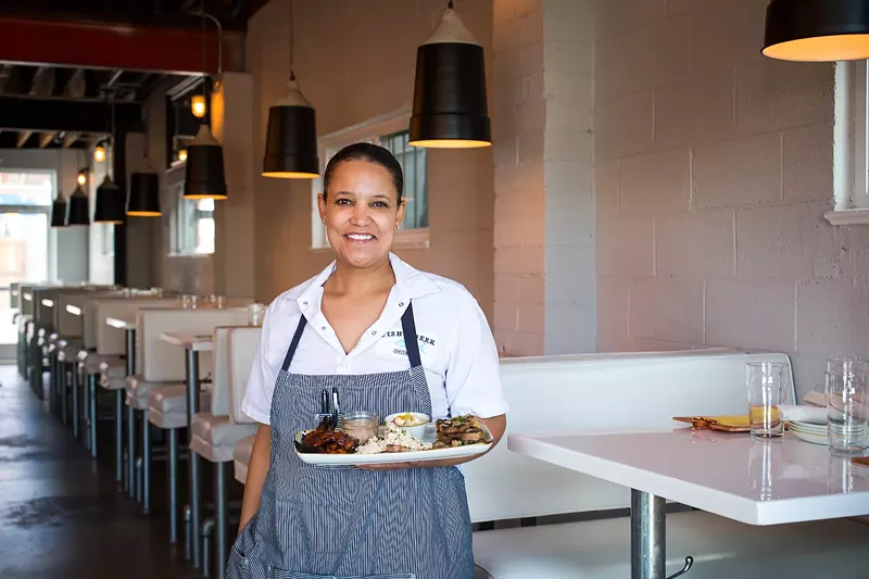 Image: Chef/partner Aniedra Nichols holds a platter of seafood charcuterie in the dining room at Fish N Beer.
