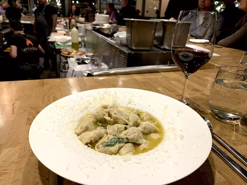 Image: Bowl of tortellini in brodo with a glass of montepulciano at Cattivella.