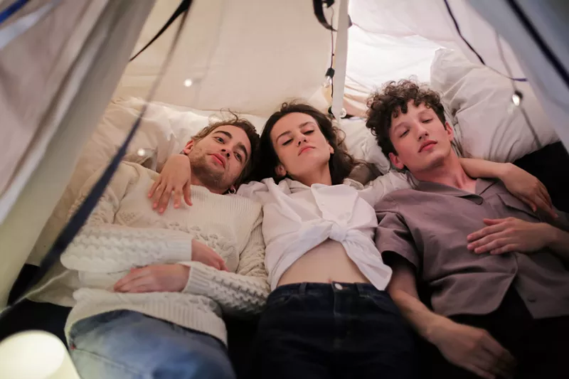 Image: Three people cuddle in bed