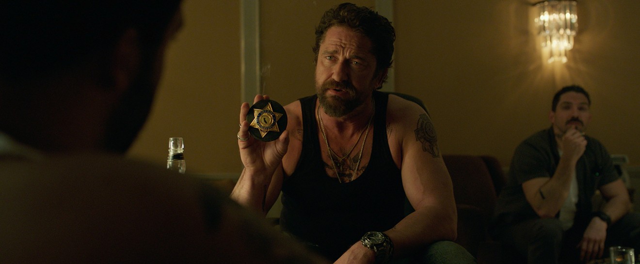 Gerard Butler (middle), playing  the swaggering boss of “the Regulators,” appears with Maurice Compte in a scene from Christian Gudegast’s Den of Thieves.