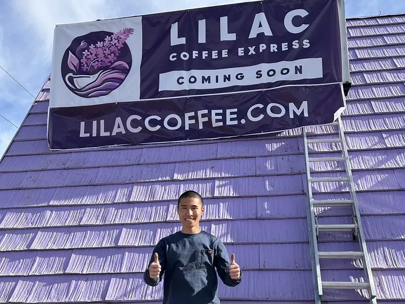 Image: a man standing in front of a purple building