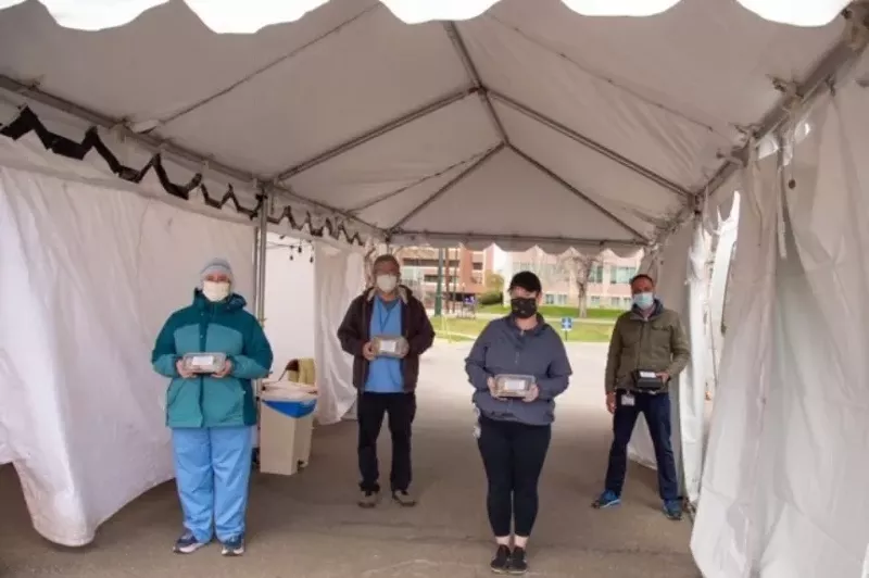 Image: Hospital workers practice social distancing hile receiving meals from Frontline Foods.
