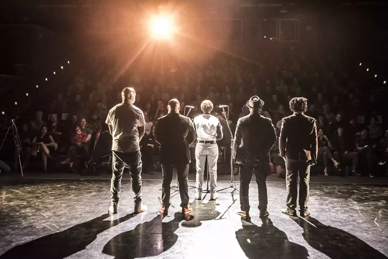 Image: A stage of people with their backs turned