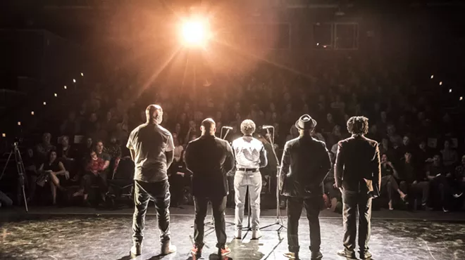 A stage of people with their backs turned