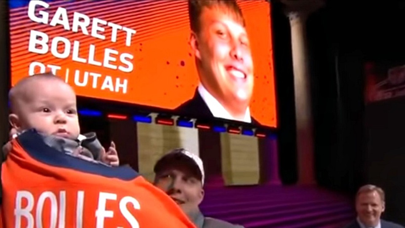 Garett Bolles and his young son celebrate at the NFL draft as Commissioner Roger Goodell looks on.