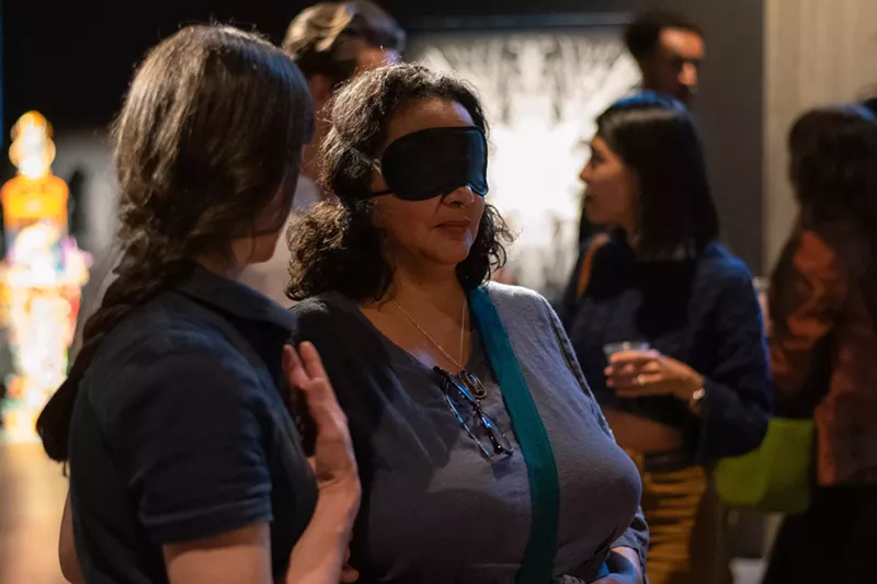 Image: Blindfolded woman explores an art gallery.