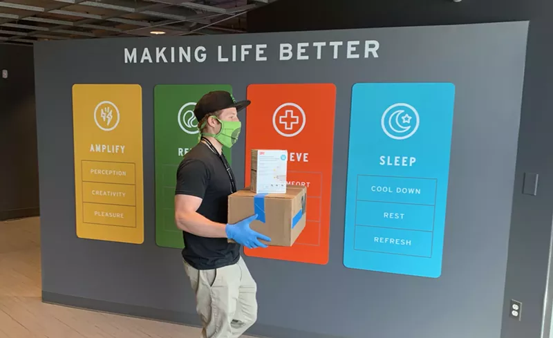 Image: A Good Chemistry employee carries N95 masks out of the dispensary and toward a good cause.