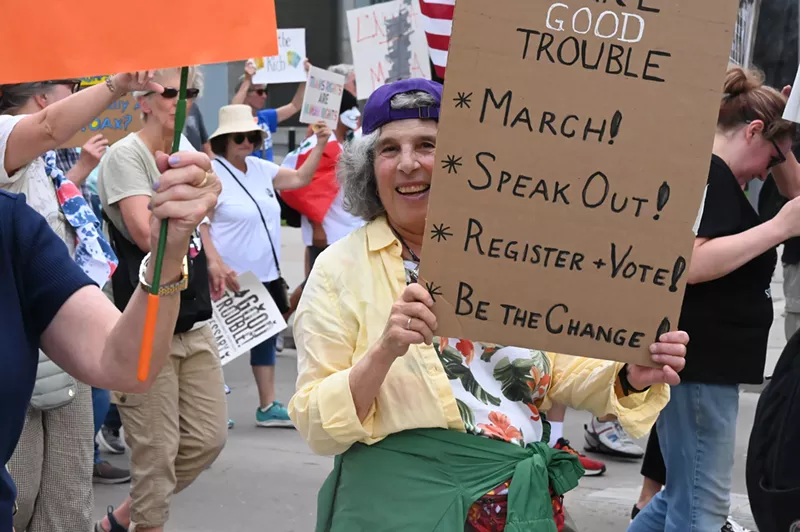 Image: A protester holds up a sign.