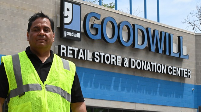 A man stands in front of a store.