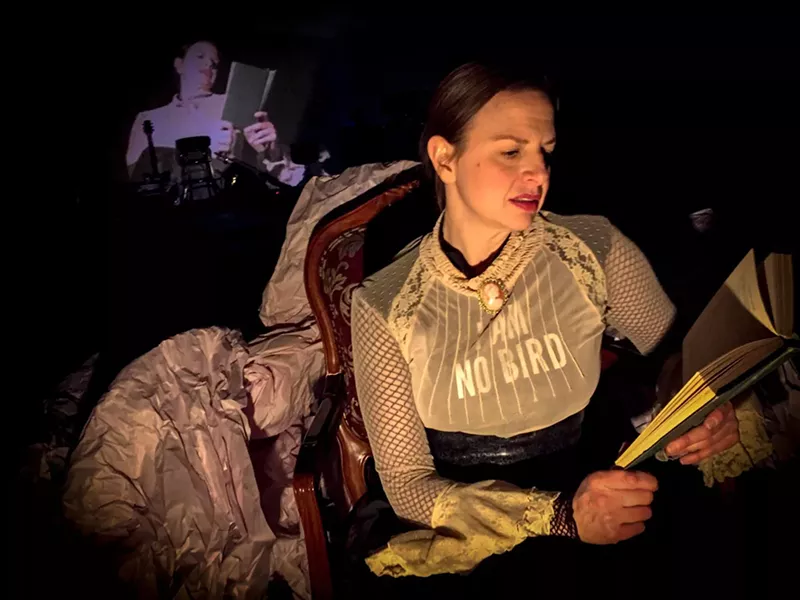 Image: A woman sits in an old-fashioned chair, reading a book, while her image is projected behind her.