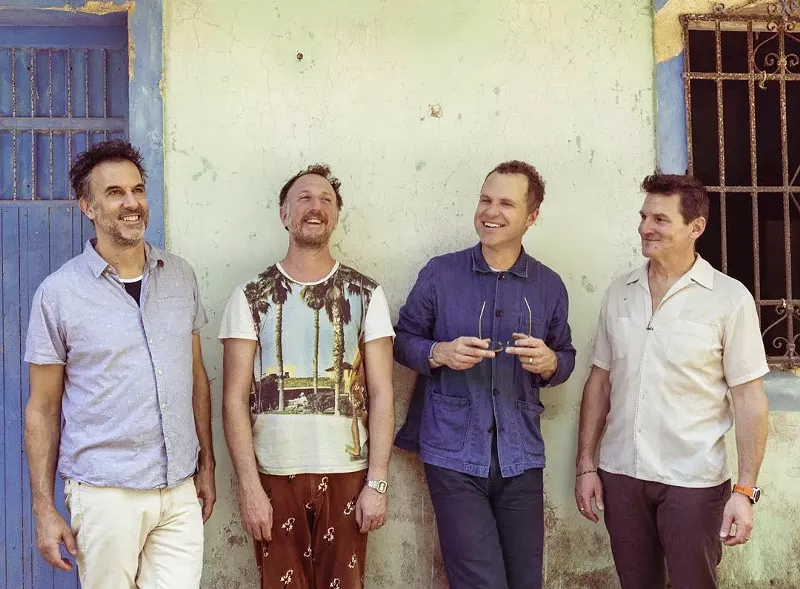 Image: members of the band guster lean against a wall