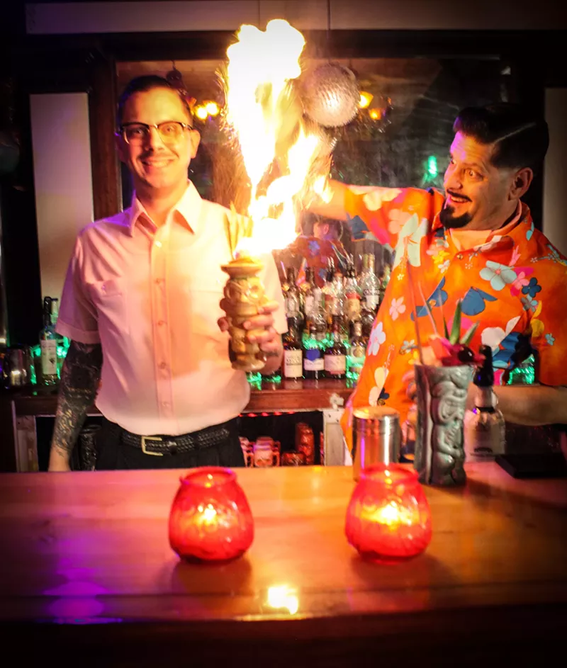 Image: Bartenders Ben Krajenke and Allister Obey serve flaming craft cocktails at Hidden Idol.