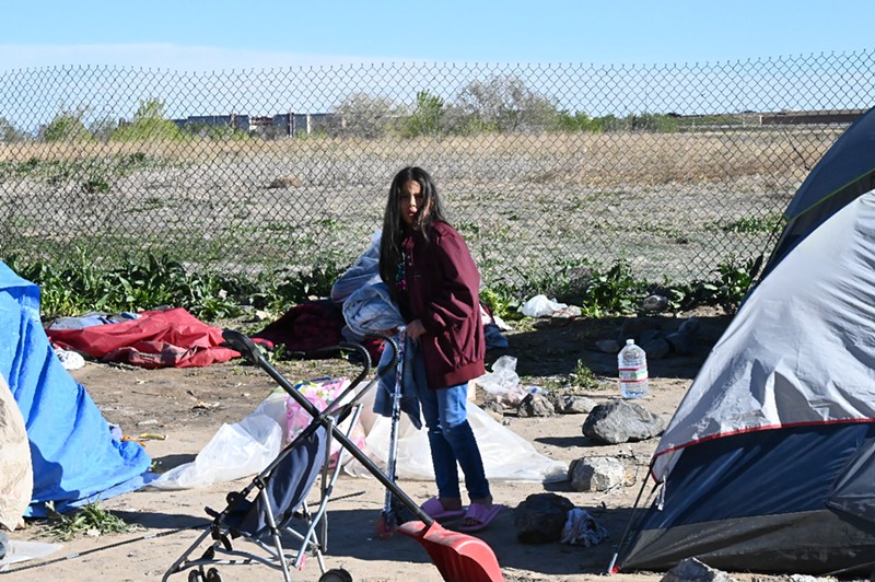 A migrant child named Wendy rides her scooter through an emaciated migrant encampment during a sweep.