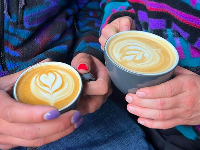 Image: hands holding two lattes