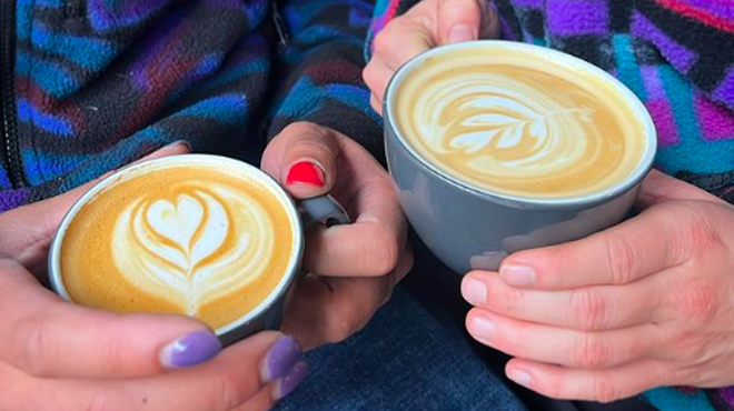 hands holding two lattes