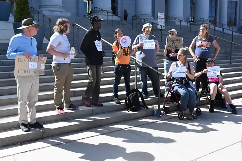 Image: Activists hold signs at Denver City and County Building
