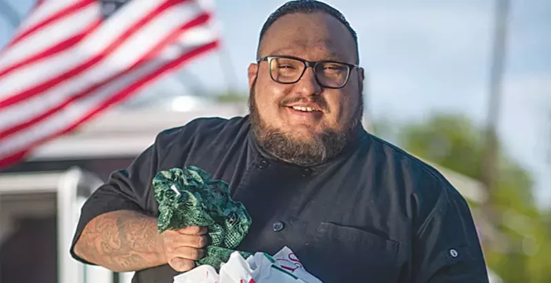 Image: man in front of flag with green chiles