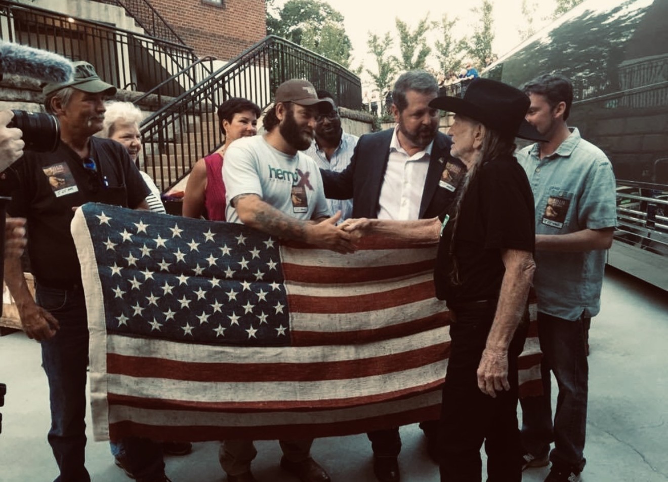 Michael Bowman (third from right upfront) meets with Willie Nelson as he holds his historic hemp flag after a Nelson performance in Charlottesville, Virginia.