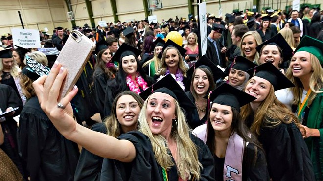 Colorado State University graduates take a photo in their caps