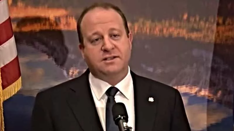 Image: Colorado Governor Jared Polis at the podium.