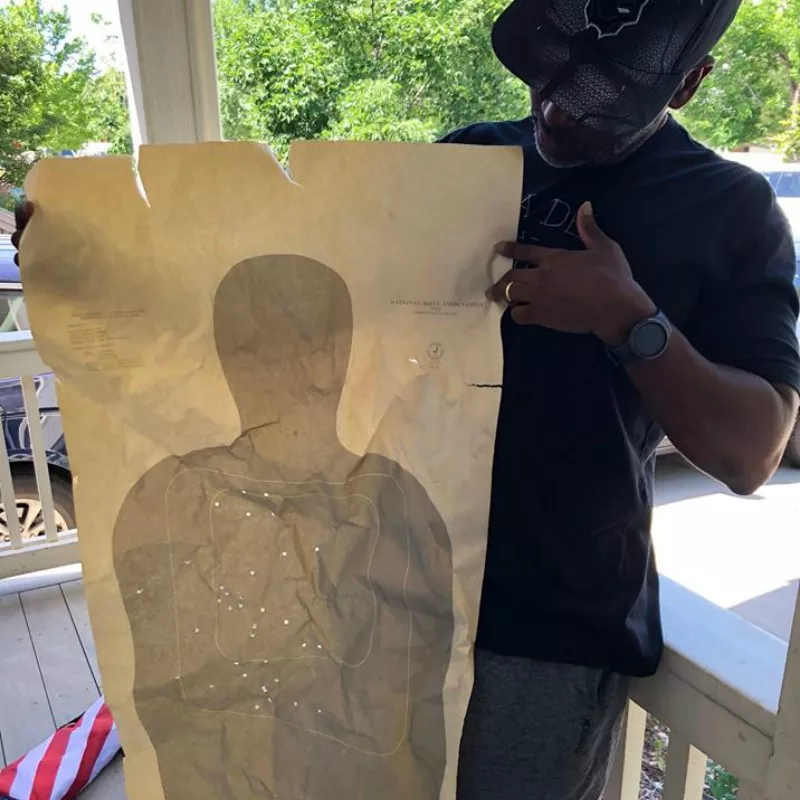Image: A Mike Johnston supporter displaying a bullet-riddled target that was left in his yard.