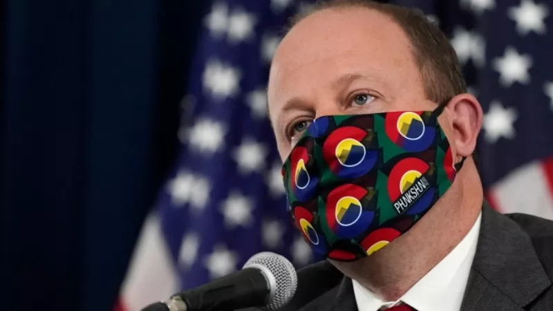 Image: A portrait of a masked Governor Jared Polis.