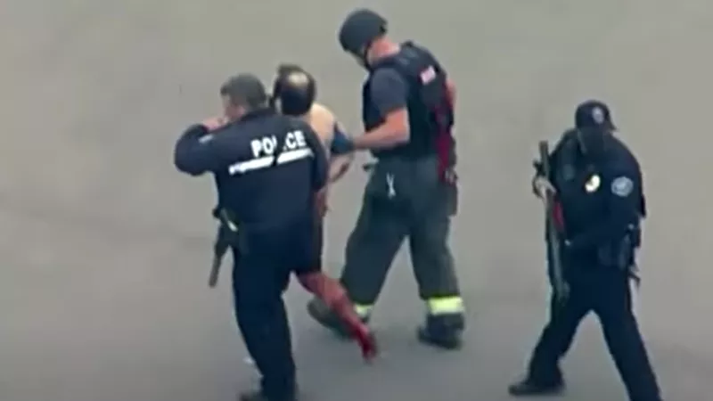 Image: The King Soopers shooting suspect being led away from the scene by police officers.