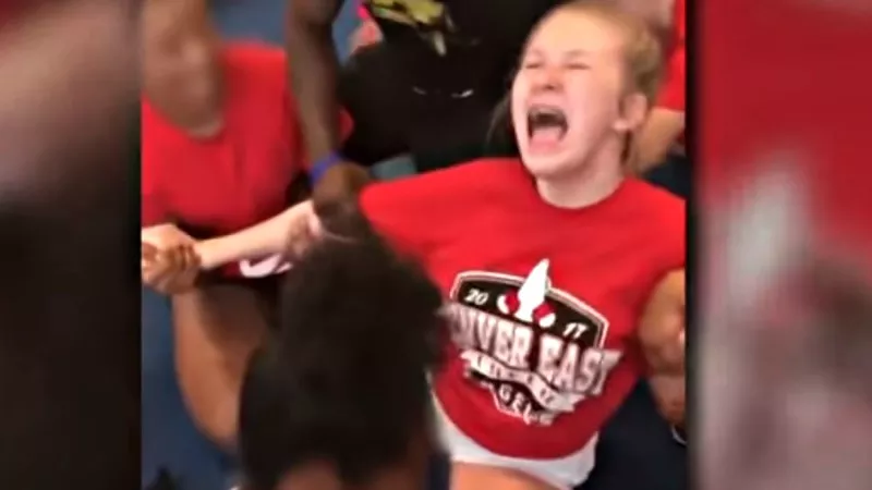 Image: East High cheerleader Ally Wakefield being forced into the splits position.
