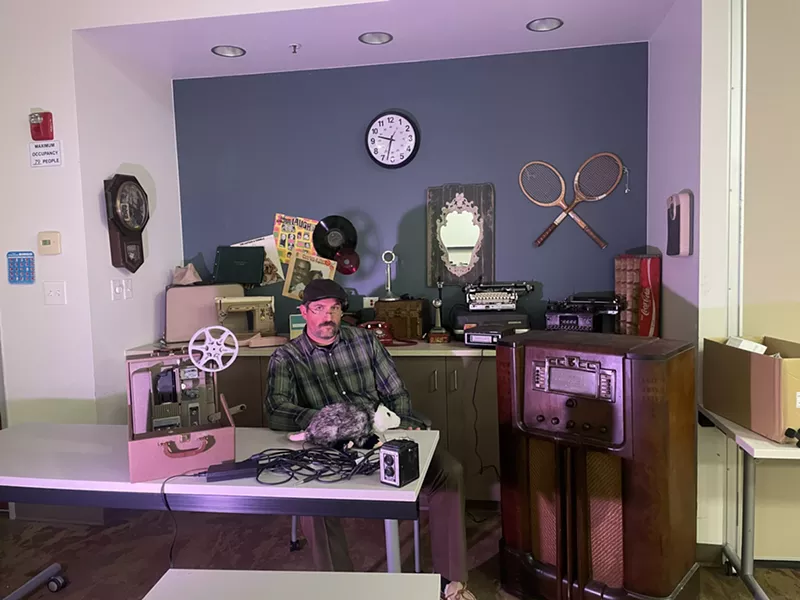 Image: Man sits around retro technology.