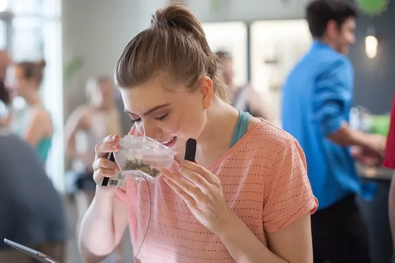 Image: A woman smells cannabis during a tour of dispensaries in Denver.