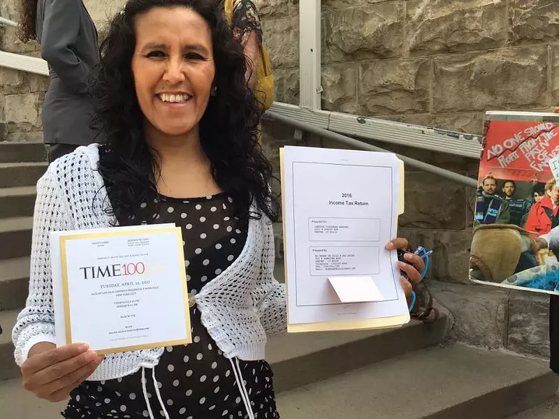 Image: Jeanette Vizguerra holds up a copy of her certificate certifying that she was named one of Time Magazine's 100 most influential people in the world.