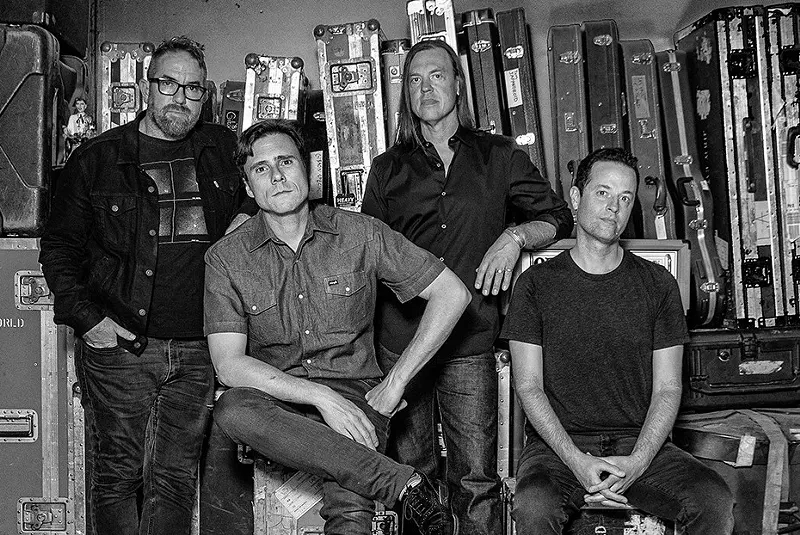 Image: four men standing in front of music equipment