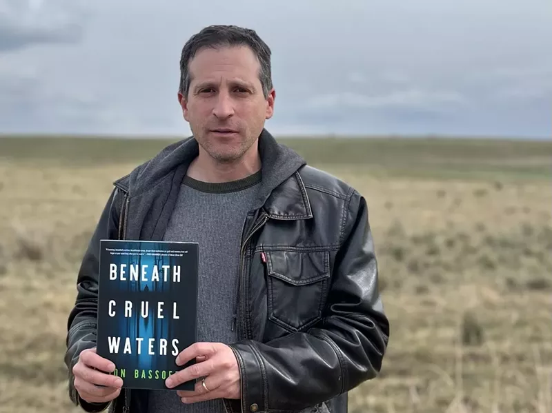 Image: Jon Bassoff, with his latest novel, in the Colorado plains.