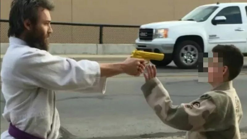 Image: This image from Joshua Cummings' Instagram page shows him pointing an imitation weapon at one of his students (whose identity we've disguised) at a Texas-based jiu-jitsuka academy. Additional images below.