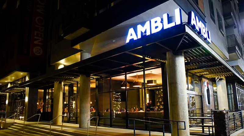 Image: lit "ambli" sign over the front of a restaurant