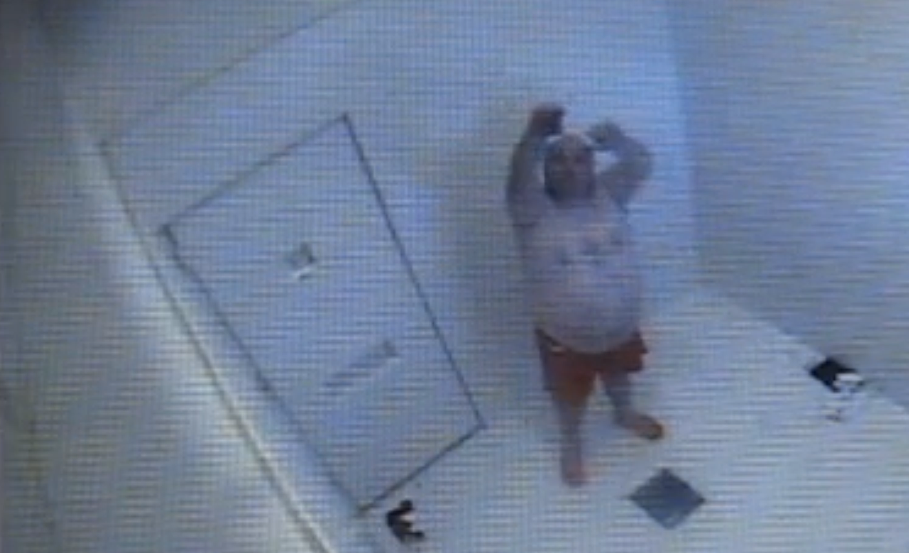 Alone in an observation cell, Justin Stieb waves at the camera in an effort to summon officers fifteen minutes before his fatal collapse on August 16, 2014.