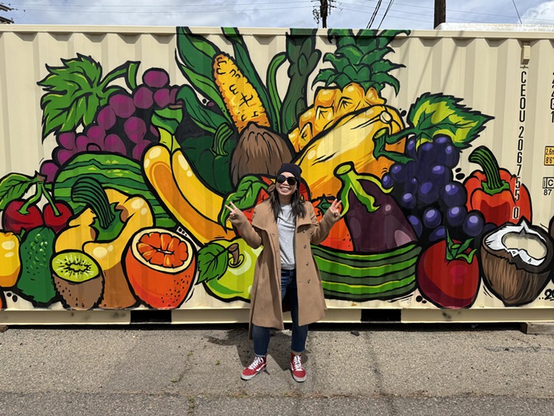 Thai Nguyen in front of a mural by Ratha Sok (@_rathasok) by Kaizen Food Rescue.
