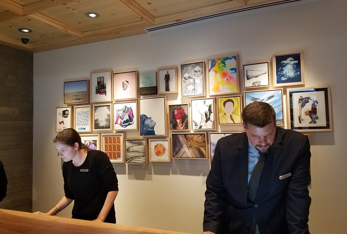 The wall behind the front desk displays a piece from each of the artists shown elsewhere in the Hotel Born.